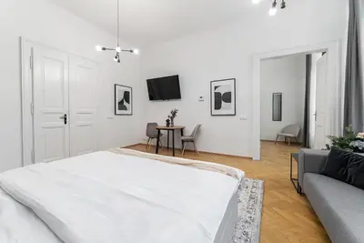 a white bedroom with a bed and a table at 2# Fancy share Apartment with Own Bathroom in Prague