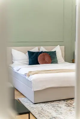 a bed with white sheets and pillows on it at 2# Fancy share Apartment with Own Bathroom in Prague