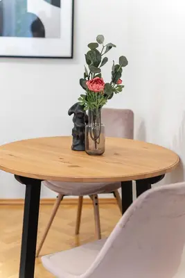 a vase with a rose sitting on a wooden table at 2# Fancy share Apartment with Own Bathroom in Prague