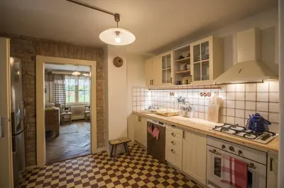 a kitchen with white cabinets and a checkered floor at Chalupa pod Řípem in Straškov