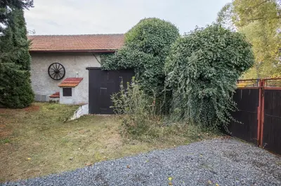 a house with a black fence and a yard at Chalupa pod Řípem in Straškov