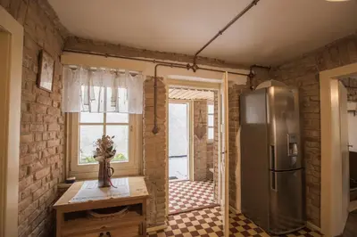a kitchen with a refrigerator and a table and a window at Chalupa pod Řípem in Straškov
