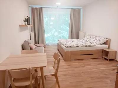 a bedroom with a bed and a table and a dining room at Apartmán IRIS Poděbrady in Poděbrady