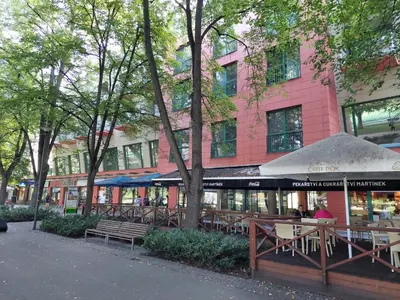 a restaurant with tables and chairs and a building at Apartmán IRIS Poděbrady in Poděbrady