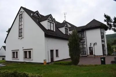 a white house with a black roof at Penzion Škubánek in Mladá Boleslav