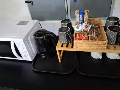 a counter with a microwave and a table with a coffee maker at Penzion Škubánek in Mladá Boleslav