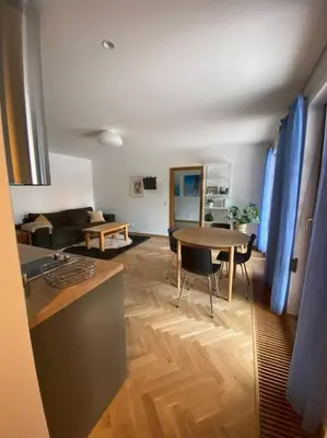 a kitchen and a living room with a table at 2+kk se vstupem na zahradu in Prague