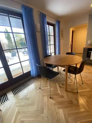 a dining room with a wooden table and chairs at 2+kk se vstupem na zahradu in Prague