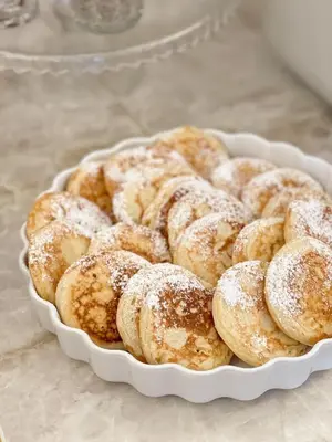 a white bowl filled with powdered sugar covered donuts at PAPPAS hotel&studio in Poděbrady
