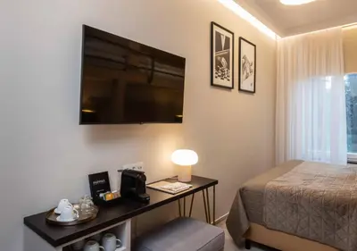 a bedroom with a bed and a desk with a television at PAPPAS hotel&studio in Poděbrady