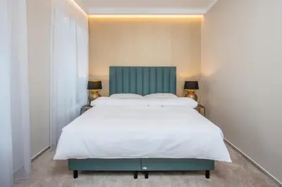 a bedroom with a large white bed and two lamps at PAPPAS hotel&studio in Poděbrady
