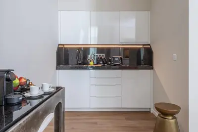 a kitchen with white cabinets and a counter top at PAPPAS hotel&studio in Poděbrady