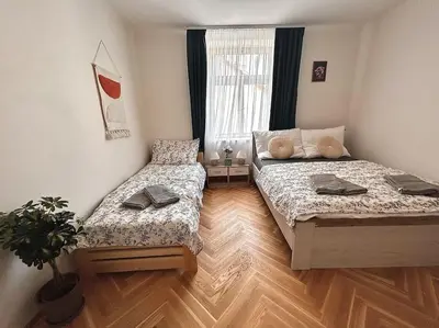 a bedroom with two beds and a potted plant at NewAPT next to Wenceslas Square in Prague
