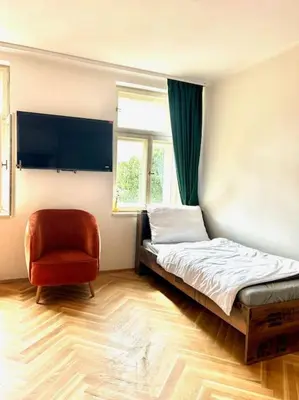 a bedroom with a bed and a chair and a window at NewAPT next to Wenceslas Square in Prague