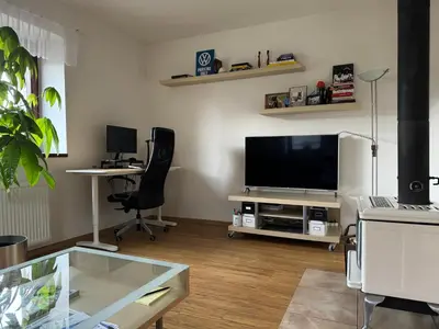 a living room with a flat screen tv and two chairs at Dům ve Vraňanech in Mělník