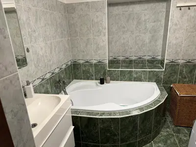 a bathroom with a white tub and a sink at Dům ve Vraňanech in Mělník