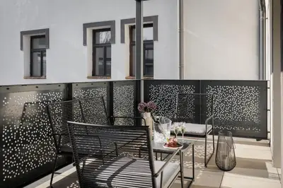 a balcony with two chairs and a table with flowers at River Apartments in Mladá Boleslav
