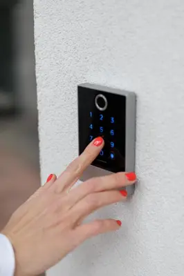 a woman pressing a button on a wall with her hand at River Apartments in Mladá Boleslav
