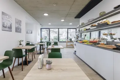 a restaurant with green chairs and tables and a counter at River Apartments in Mladá Boleslav