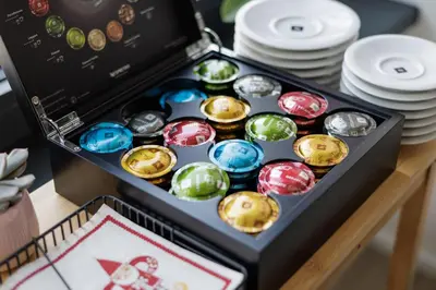 a box of chocolates on a table with plates at River Apartments in Mladá Boleslav