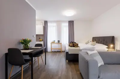 a bedroom with a bed and a table and a couch at River Apartments in Mladá Boleslav