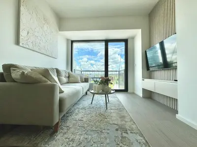 a living room with a couch and a table at Rentero NEW Modern, River View APT near Prague City Center in Prague