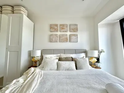 a bedroom with a large bed with white sheets and pillows at Rentero NEW Modern, River View APT near Prague City Center in Prague