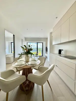 a kitchen and dining room with a table and chairs at Rentero NEW Modern, River View APT near Prague City Center in Prague