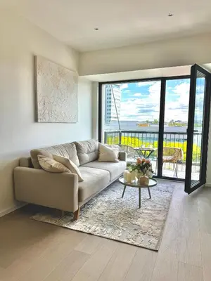 a living room with a couch and a table at Rentero NEW Modern, River View APT near Prague City Center in Prague