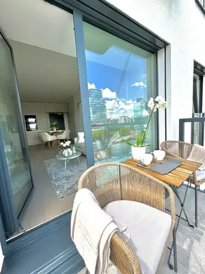 a balcony with a table and chairs and a view at Rentero NEW Modern, River View APT near Prague City Center in Prague