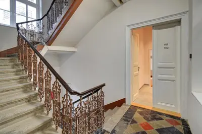 a staircase in a home with white walls and wooden railings at Prague Milada & Heaven Home Apartment in Prague