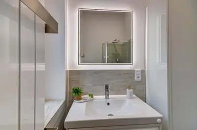 a white bathroom with a sink and a mirror at Prague Milada & Heaven Home Apartment in Prague