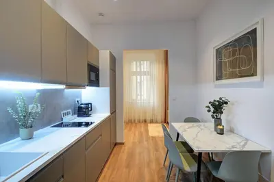 a kitchen with a counter and a table with chairs at Prague Milada & Heaven Home Apartment in Prague