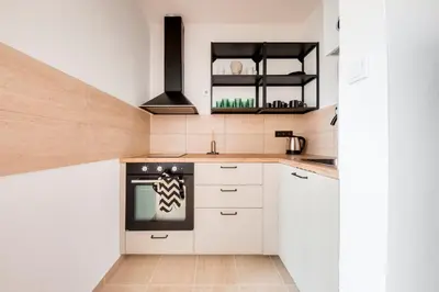 a kitchen with white cabinets and a black oven at City center premium apartment Bohemia in Prague