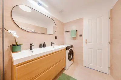a bathroom with a sink and a washing machine at City center premium apartment Bohemia in Prague