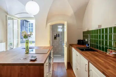 a kitchen with a sink and a counter with green tiles at Prague Days - Two-bedroom Apartment with Workspace and Balcony in Old Town in Prague