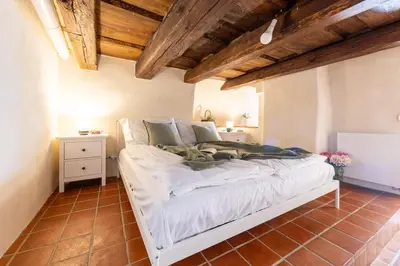 a large white bed in a room with wooden ceilings at Prague Days - Two-bedroom Apartment with Workspace and Balcony in Old Town in Prague