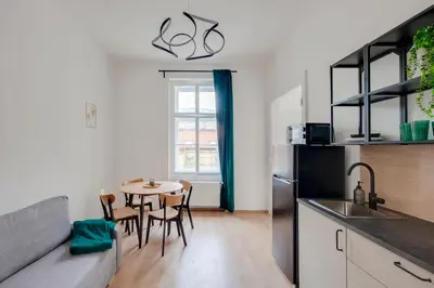 a kitchen and dining room with a table and a refrigerator at City center premium apartment in Prague