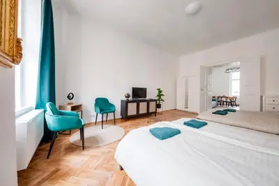 a bedroom with two beds and a desk and chairs at City center premium apartment in Prague
