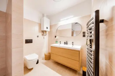 a bathroom with a sink and a toilet and a mirror at City center premium apartment in Prague