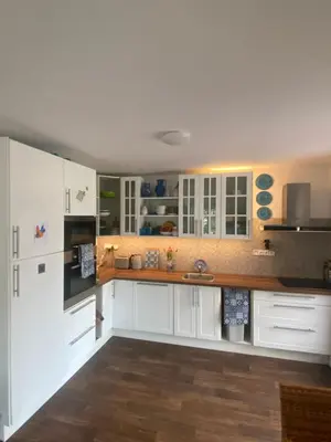 a kitchen with white cabinets and a wooden floor at Doma na Lipníku-private country house, homestay in Lipník