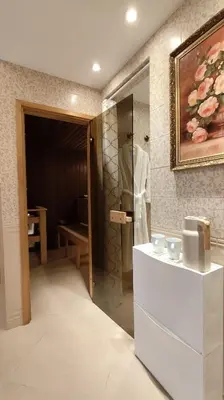a bathroom with a shower with a white robe in it at Apartmány U Obory in Nechánice