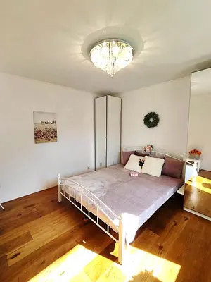 a bedroom with a bed and a chandelier at Apartmány U Obory in Nechánice