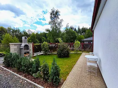a backyard with a garden with a grill and some bushes at Apartmány U Obory in Nechánice