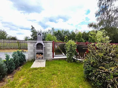 a backyard with a brick oven in the grass at Apartmány U Obory in Nechánice