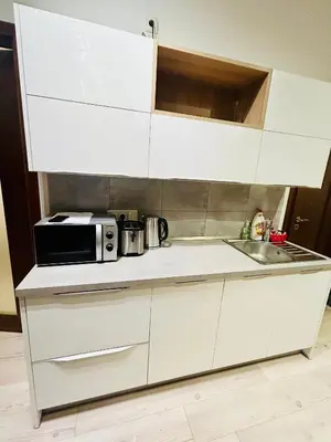 a white kitchen with a microwave and a sink at Modern Spacious Apartment in center Prague in Prague