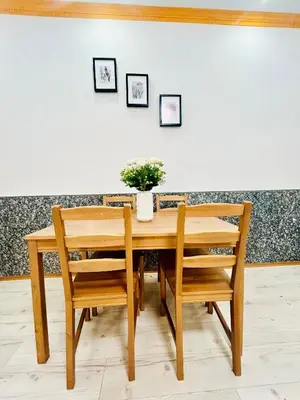 a wooden table with two chairs and a vase with flowers at Modern Spacious Apartment in center Prague in Prague