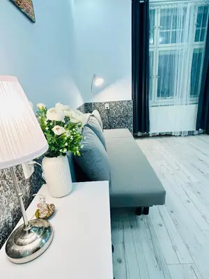a living room with a couch and a table with a lamp at Modern Spacious Apartment in center Prague in Prague