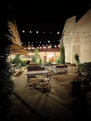 a group of benches and tables in a courtyard at night at hotel Florian Sedlčany in Sedlčany