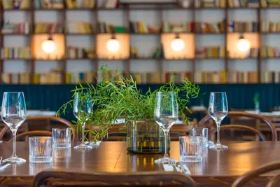 a wooden table with glasses and a plant on it at Glamping pospolu in Mokrovraty